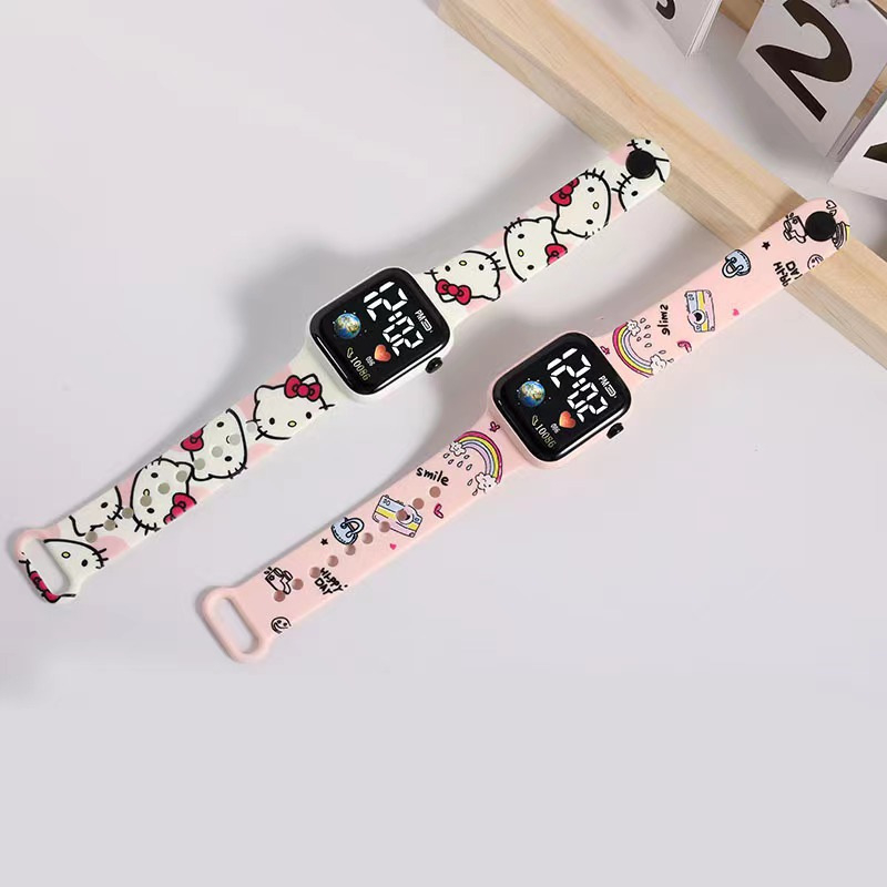 Rokas pulkstenis ar elektronisko kustību un ciparu displeju, karikatūras druka ar sirsniņas formu kvadrāta Zemes motīvā, plastmasas korpuss un siksna (Kustība: Elektroniska; Displejs: Skaitļi; Forma: Kvadrāts; Korpuss: Plastmasas; Siksna: Plastmasas)