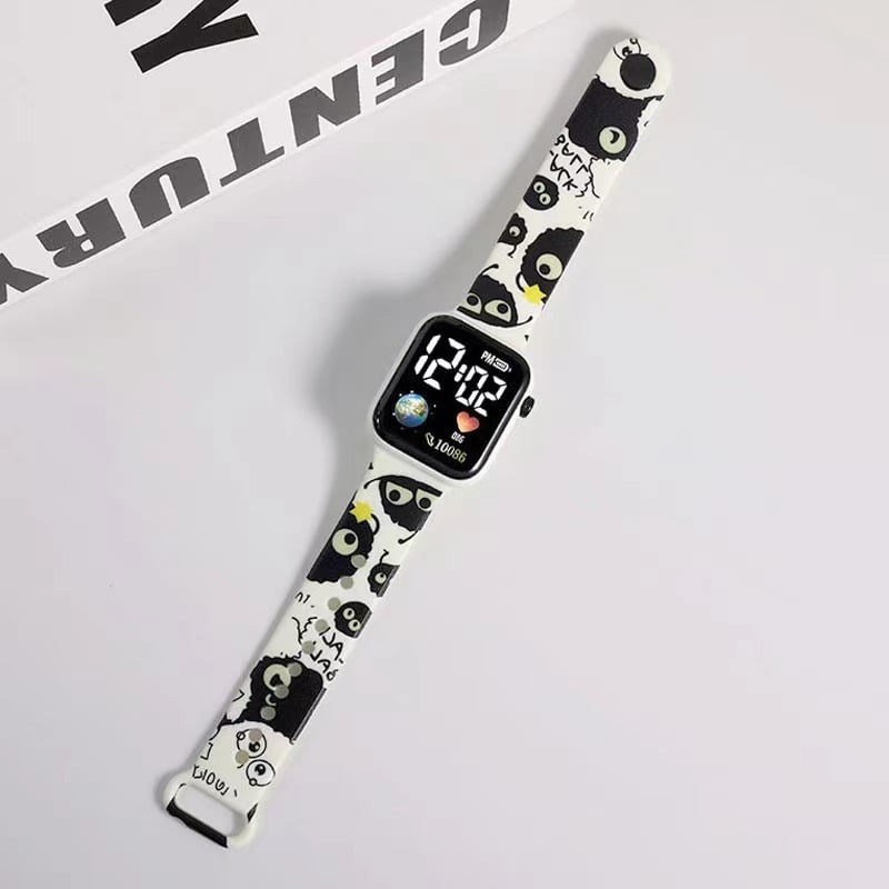 Rokas pulkstenis ar elektronisko kustību un ciparu displeju, karikatūras druka ar sirsniņas formu kvadrāta Zemes motīvā, plastmasas korpuss un siksna (Kustība: Elektroniska; Displejs: Skaitļi; Forma: Kvadrāts; Korpuss: Plastmasas; Siksna: Plastmasas)