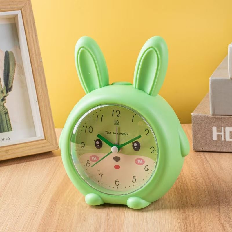 Tanulók számára tervezett karikatúra-stílusú asztali ébresztőóra, kompakt kivitel, Seiko kvarcs mozgás, sima másodpercmozgás, LCD‑ és analóg kijelző, akkumulátorral működik, műanyag ház, 4,8 cm vastagság