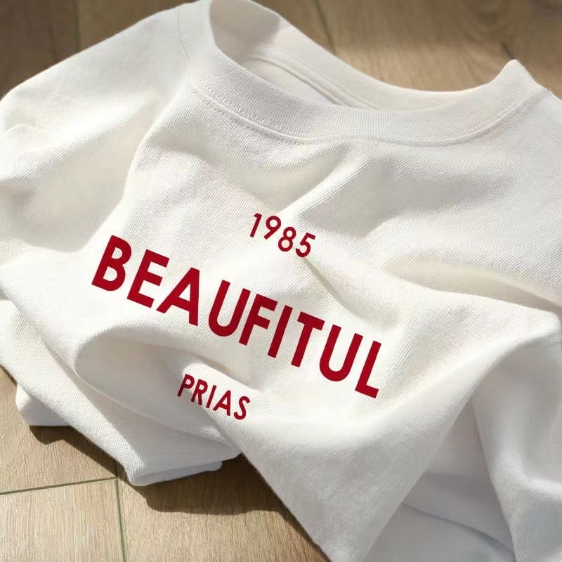 Kokvilnas T-krekls ar īsām piedurknēm, burtiem drukāts, apaļš kakls, brīvs piegriezums (95%+ kokvilna; drukāšana; burti/teksti; parasta garums)