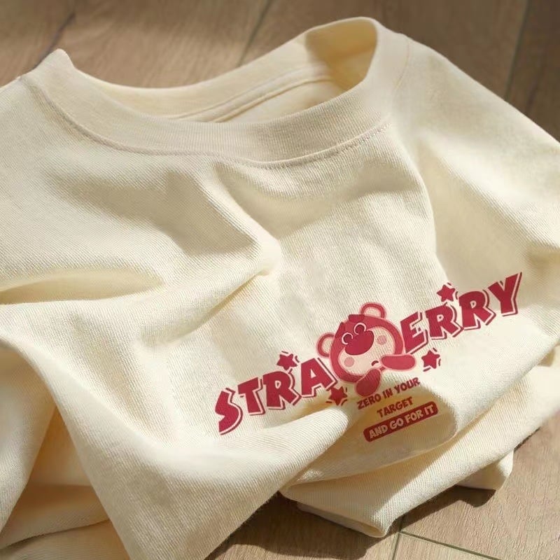 Kokvilnas T-krekls ar īsām piedurknēm, burtiem drukāts, apaļš kakls, brīvs piegriezums (95%+ kokvilna; drukāšana; burti/teksti; parasta garums)