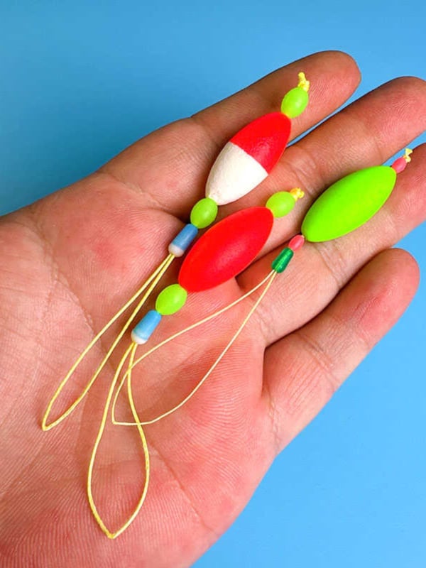 Makšķerēšanas līnijas piederums ar pastiprinošu stieni, luminescējošu pērlīti un galvenās līnijas savienotāju