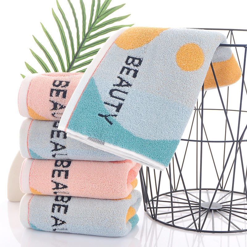 Kokvilnas sejas dvielis ar biezu tekstūru, mīksts un labi uzsūcošs; burti izšūti krāsu blokos (Materiāls: kokvilna; Diegi: 16s; Ražošanas process: apdare, vienkāršs audums; Svars: 120–140 g; Tips: sejas dvielis)