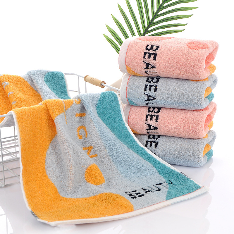 Kokvilnas sejas dvielis ar biezu tekstūru, mīksts un labi uzsūcošs; burti izšūti krāsu blokos (Materiāls: kokvilna; Diegi: 16s; Ražošanas process: apdare, vienkāršs audums; Svars: 120–140 g; Tips: sejas dvielis)