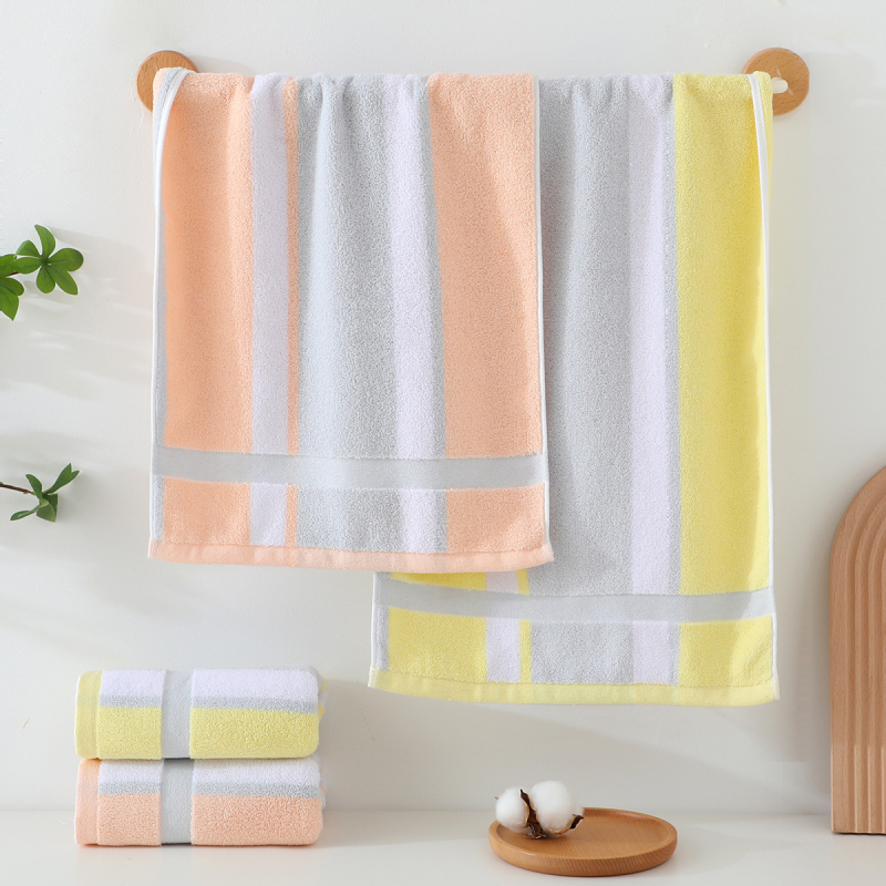 Kokvilnas sejas dvielis ar biezu tekstūru, mīksts un labi uzsūcošs; burti izšūti krāsu blokos (Materiāls: kokvilna; Diegi: 16s; Ražošanas process: apdare, vienkāršs audums; Svars: 120–140 g; Tips: sejas dvielis)