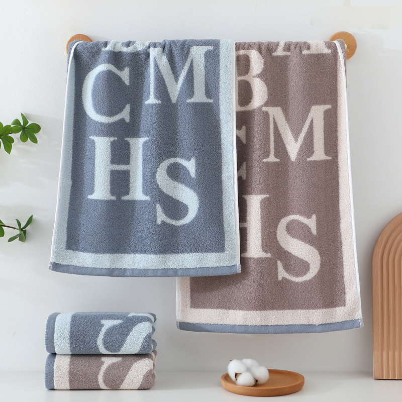 Kokvilnas sejas dvielis ar biezu tekstūru, mīksts un labi uzsūcošs; burti izšūti krāsu blokos (Materiāls: kokvilna; Diegi: 16s; Ražošanas process: apdare, vienkāršs audums; Svars: 120–140 g; Tips: sejas dvielis)