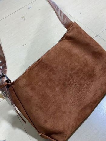 Nubuk anyagú masni alakú keresztpántos válltáska, cipzáras zsebbel és egy vállpánttal