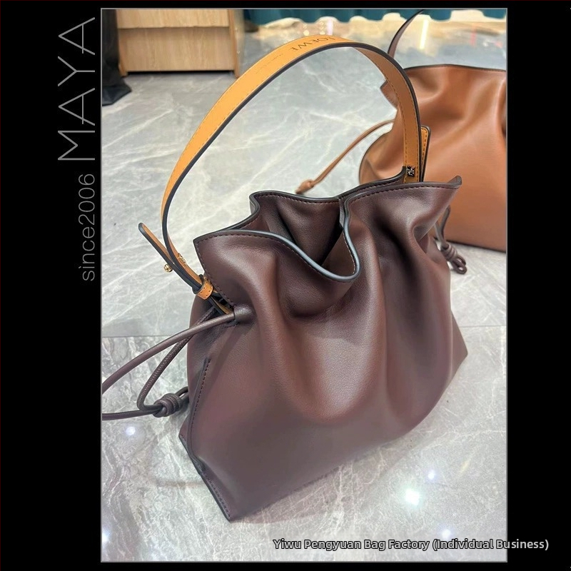 Pečių rankinė iš veršienos odos, horizontalaus kvadrato formos, atidarytas viršus, vidinė kišenė telefonui, vienas peties dirželis.