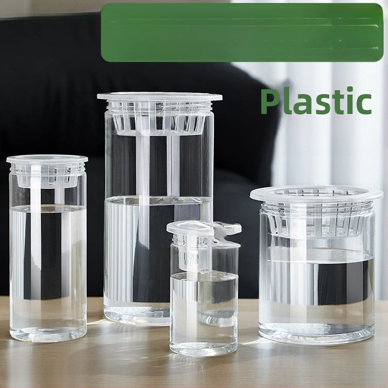 Caurspīdīgs plastmasas cilindrisks hydroponiskais pods sēklām un maziem augiem, stāvošs uz grīdas ar stādīšanas grozu, domāts mājas un dārza lietošanai