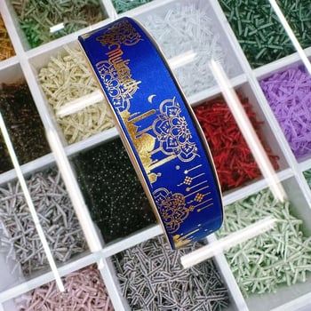 Dekoratyvinė juostelė su folijos įspaudu, motyvais: žvaigždė, mėnulis ir raidės; skirta dovanoms įvynioti ir šventinei dekoracijai