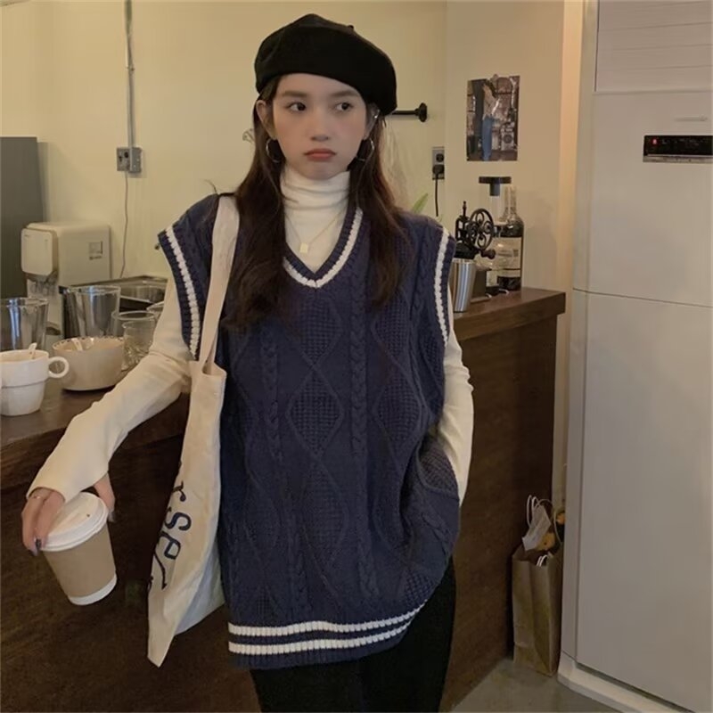 Női kötött mellény V-nyakú kivágással, színblokkolt mintával és kábelkötés részletekkel, poliészter anyag, őszi 2025