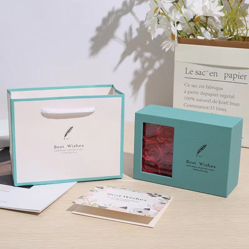 Rotaslietu iepakojuma kastīte kaklarotai un auskariem — papīra/kartona materiāls, iepakojuma veids: kastīte, iekļauj ziedu kastīti un apsveikuma kartiņu