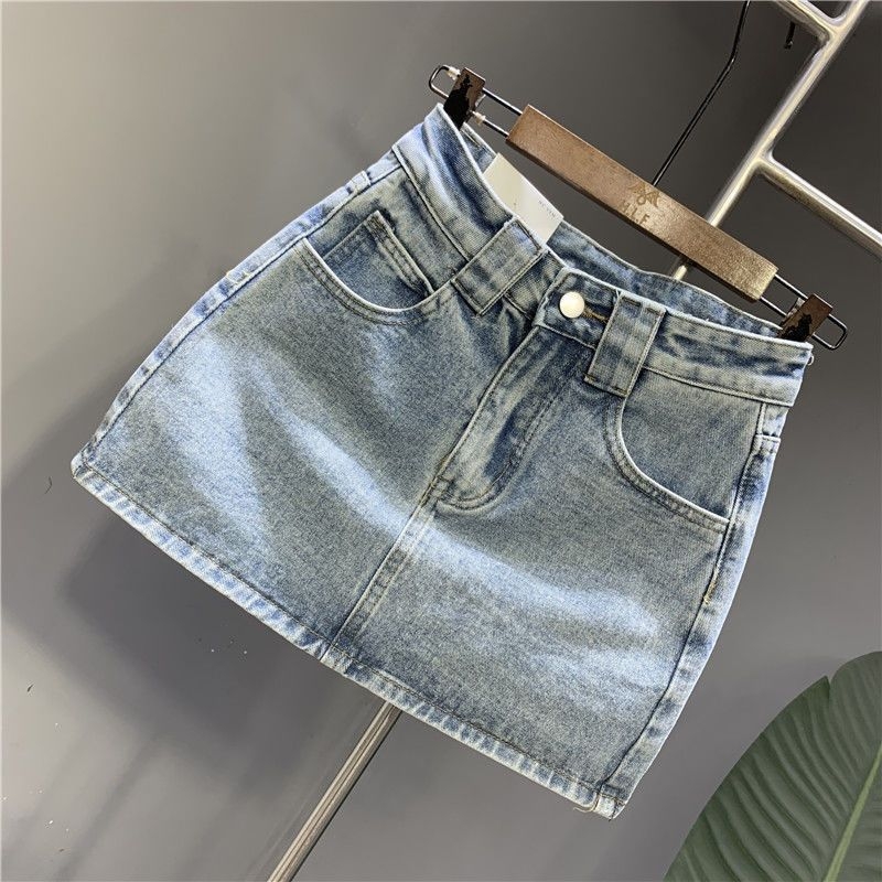 A-linijska denimska suknja s izbrušenim detaljima, zipom i gumbima – pamukasti denim, gradski stil, ljeto 2024