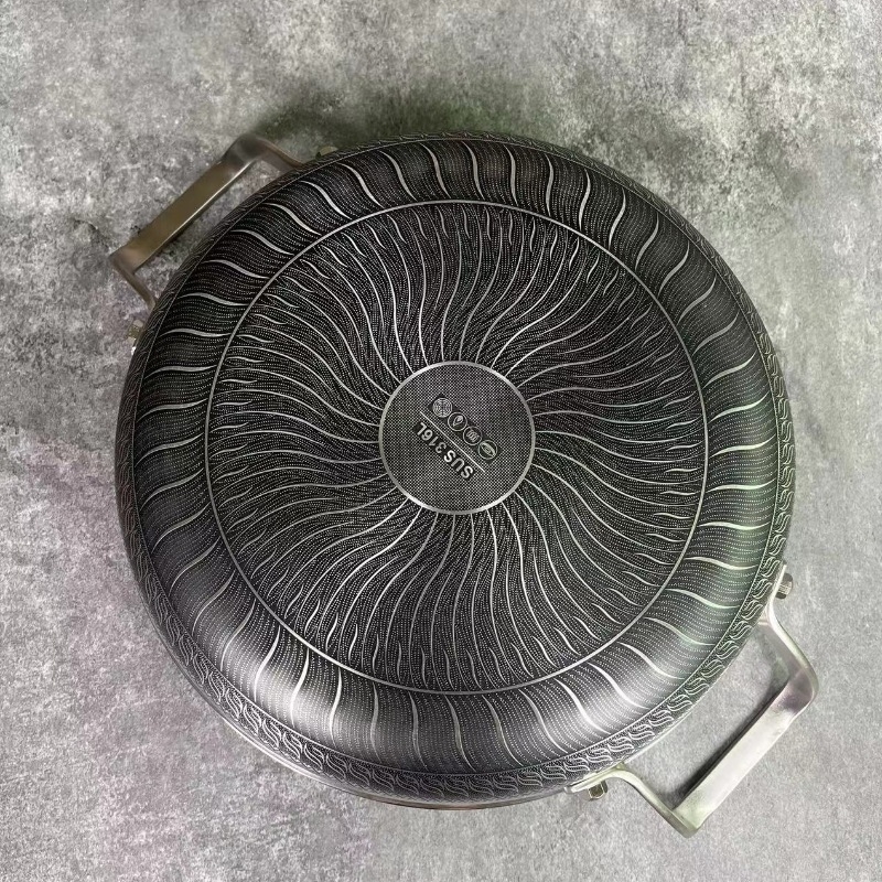 Tiga­na s dvije ručke od 316 nerđajućeg čelika, neprijanjajući premaz, trostruko dno, indukcijska kompatibilnost, stakleni poklopac, model B016