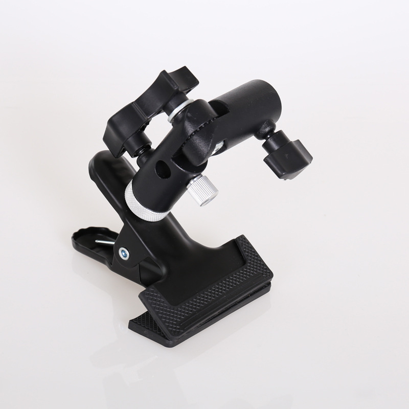 Clema foto multifuncțională cu suport pentru bliț extern, suport pentru umbrelă și clips pentru fundal; construcție din fier și aluminiu.