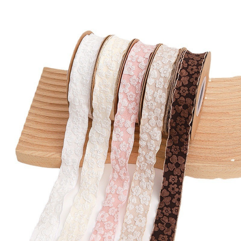 Csipkés virágcsomogoló szalag, megvastított, redőzött, reliefes virág mintával, poliészter