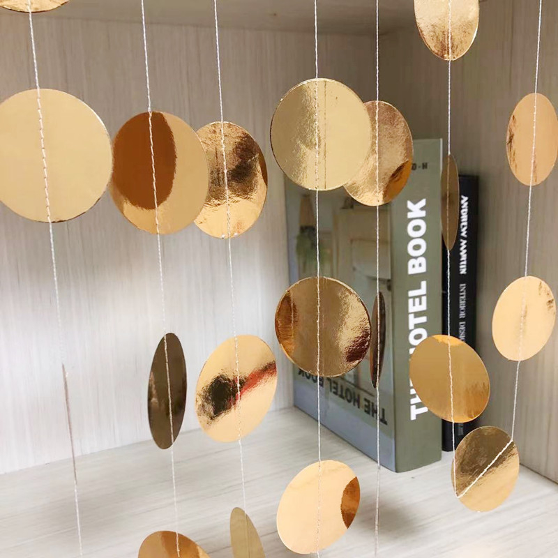 Esküvői rendezvényekhez tervezett helyszín-dekorációs kellék – kör alakú, tükrös felületű papírdísz szalaggal