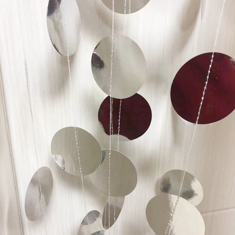 Esküvői rendezvényekhez tervezett helyszín-dekorációs kellék – kör alakú, tükrös felületű papírdísz szalaggal