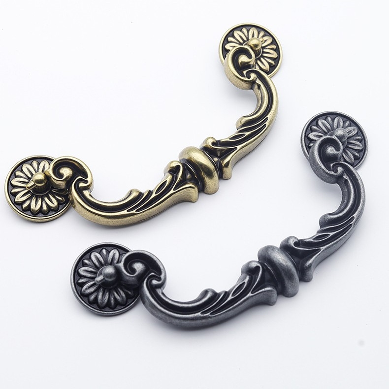 Szekrényajtó fogantyú íves kialakítású, cink ötvözet, öntés, furatok közötti távolság állítható