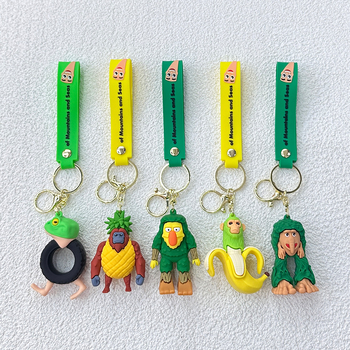 Breloc din PVC cu o figurină din lemn în formă de omuleț, purtând pantofi, și un pandantiv rechin