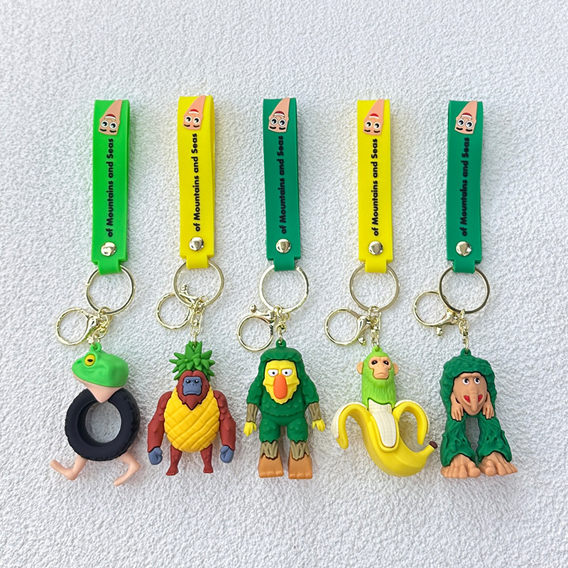 Breloc din PVC cu o figurină din lemn în formă de omuleț, purtând pantofi, și un pandantiv rechin