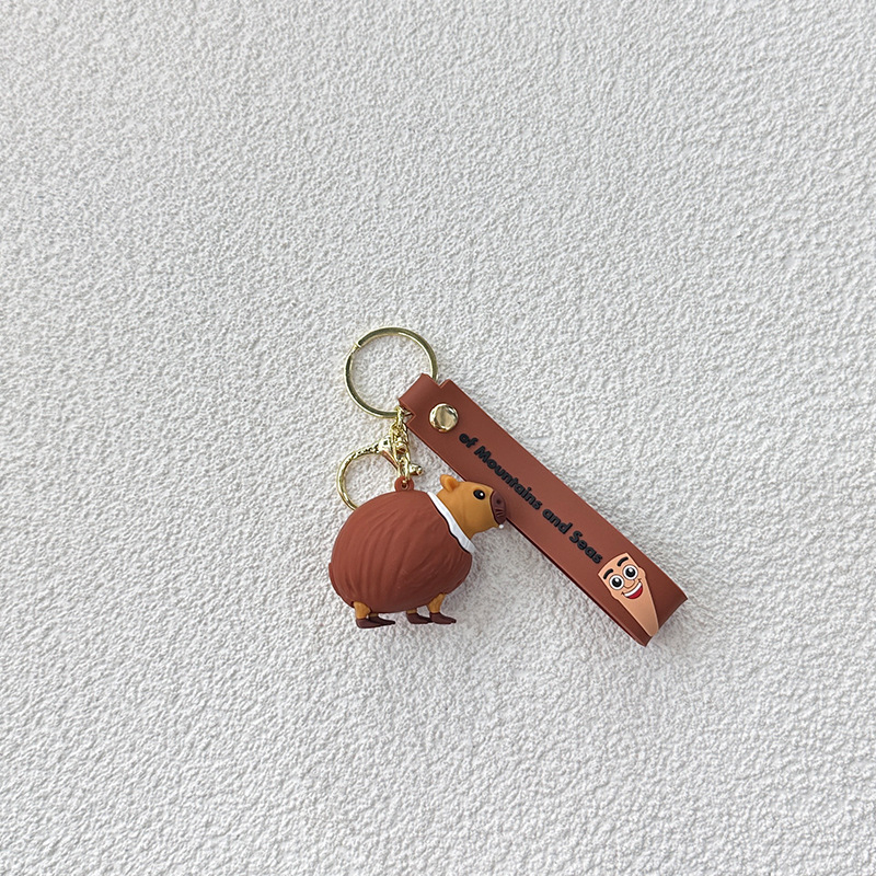 Breloc din PVC cu o figurină din lemn în formă de omuleț, purtând pantofi, și un pandantiv rechin