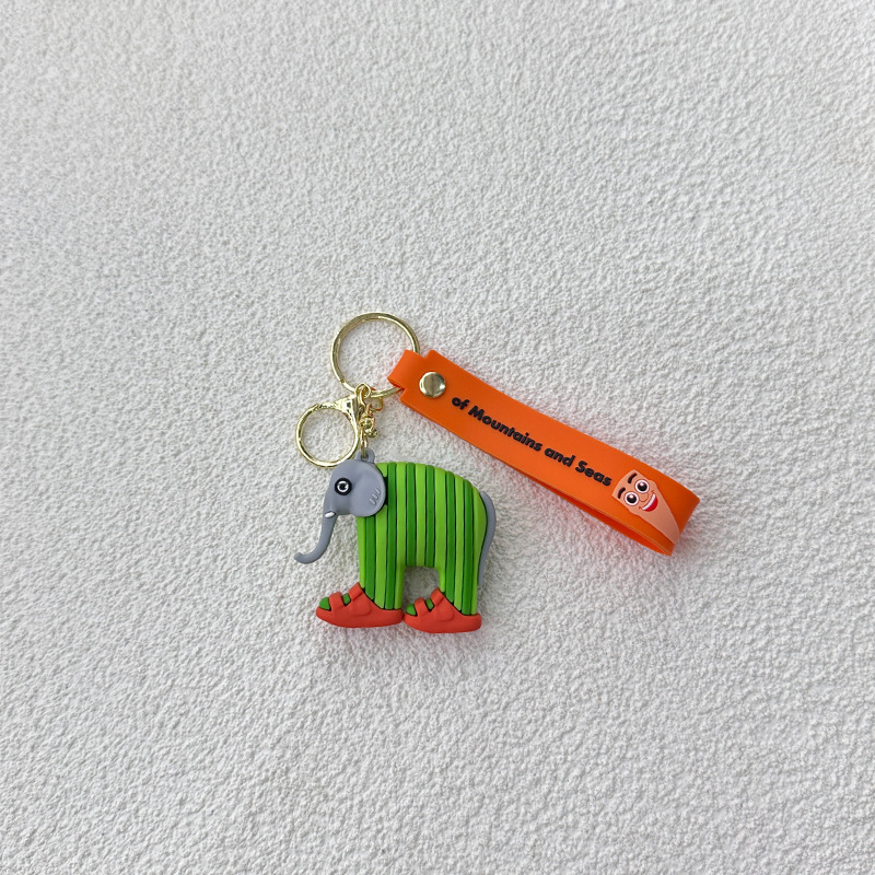 Breloc din PVC cu o figurină din lemn în formă de omuleț, purtând pantofi, și un pandantiv rechin