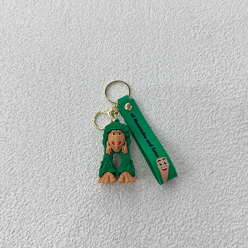 Breloc din PVC cu o figurină din lemn în formă de omuleț, purtând pantofi, și un pandantiv rechin
