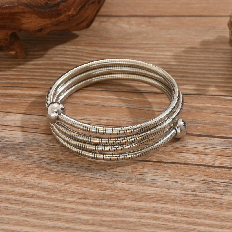 Гривна за ръка от стоманена тел с три слоя навиване и геометрични мъниста