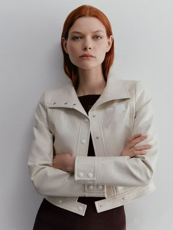 PU bőrhatású biker dzseki rever gallérral, kollázs varrás részletekkel, karcsú szabás, vékony textúra, utcai motoros stílus (Tavasz 2025)