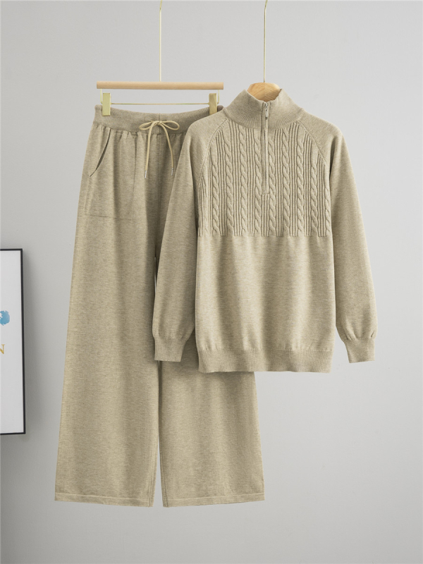 Дамски плетен костюм от две части: пуловер с половин цип и панталони с широки крачоли; монотонен десен; вискоза 50–70% и полиестер 30–50%; мотив twist-flower; дълги ръкави; есен 2025