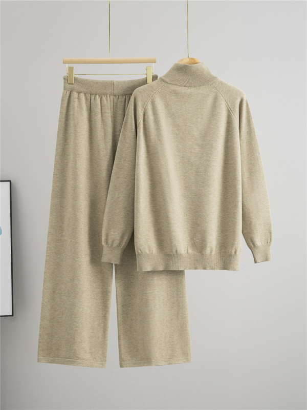 Дамски плетен костюм от две части: пуловер с половин цип и панталони с широки крачоли; монотонен десен; вискоза 50–70% и полиестер 30–50%; мотив twist-flower; дълги ръкави; есен 2025