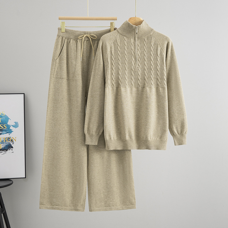 Дамски плетен костюм от две части: пуловер с половин цип и панталони с широки крачоли; монотонен десен; вискоза 50–70% и полиестер 30–50%; мотив twist-flower; дълги ръкави; есен 2025