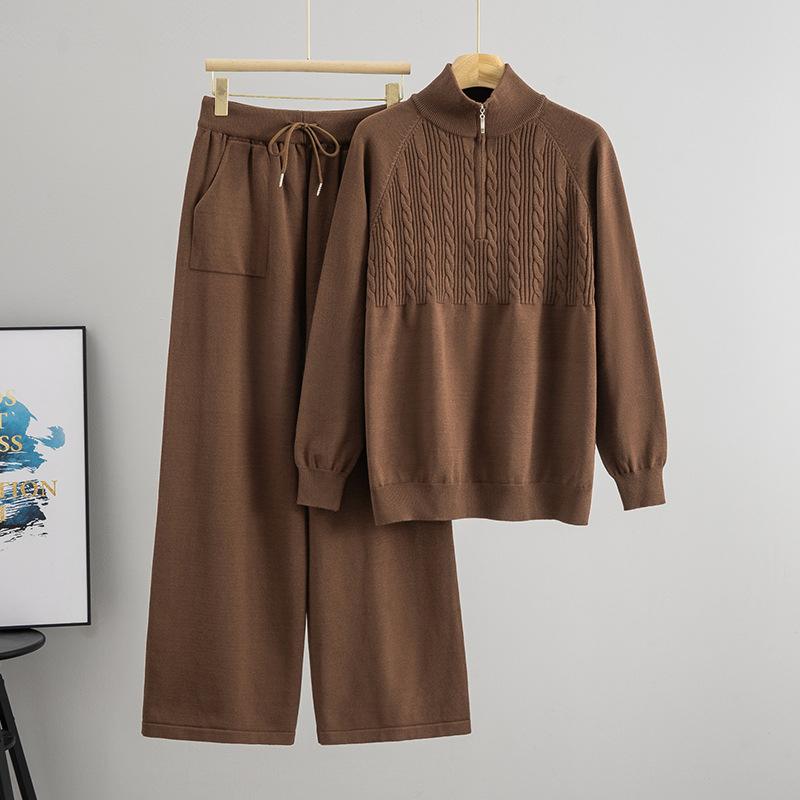 Дамски плетен костюм от две части: пуловер с половин цип и панталони с широки крачоли; монотонен десен; вискоза 50–70% и полиестер 30–50%; мотив twist-flower; дълги ръкави; есен 2025