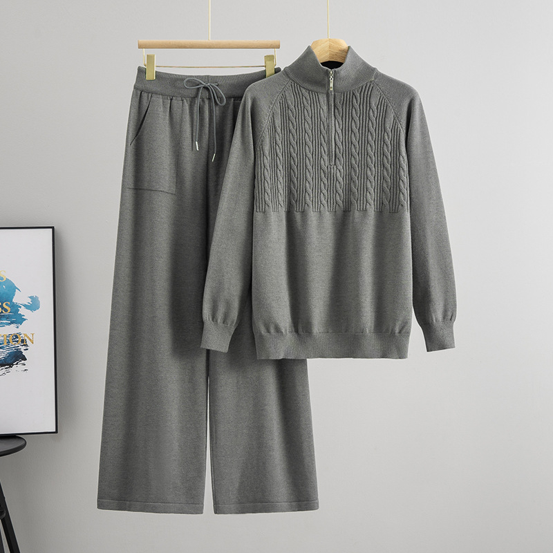 Дамски плетен костюм от две части: пуловер с половин цип и панталони с широки крачоли; монотонен десен; вискоза 50–70% и полиестер 30–50%; мотив twist-flower; дълги ръкави; есен 2025