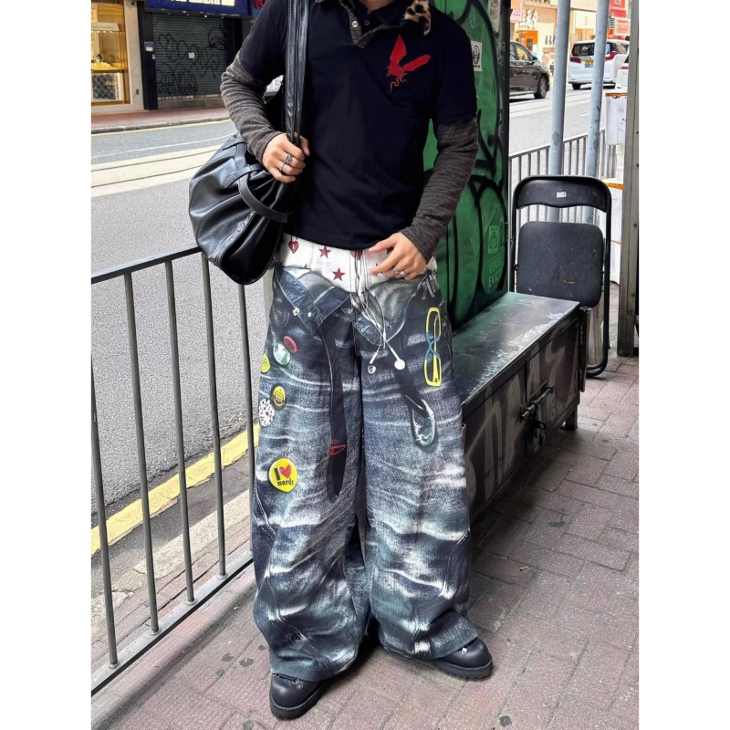 Traperice s graffiti otiskom, poderane detalje, širok i ležeran kroj, pamukasti denim, niska struka