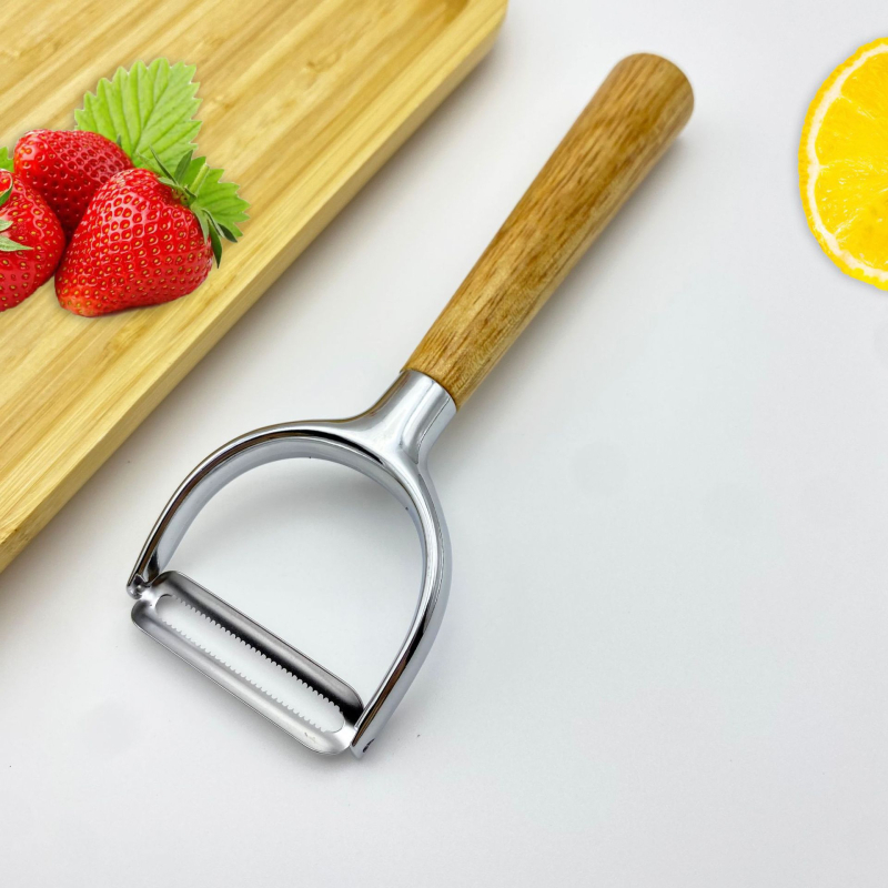 Multifunkcionális cinkötvözetből készült hántoló tölgyfa fogantyúval — hántolás, kaparó, gyümölcs- és zöldségpucoló, dinnyepucoló; logó nyomtatás; testreszabás elérhető