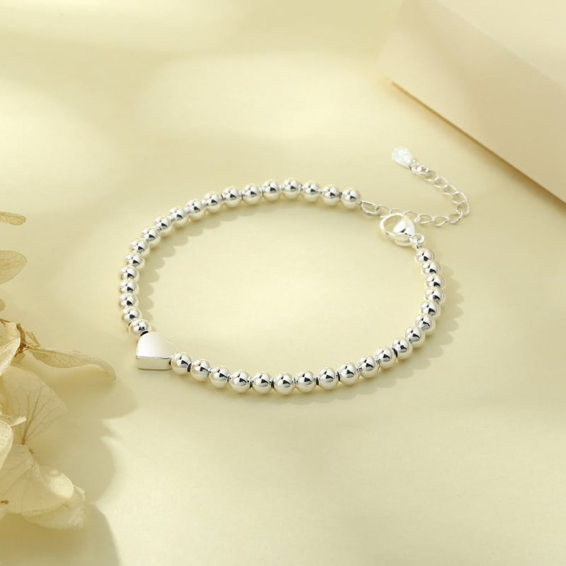 Réz alapú karkötő ezüstös bevonattal, szív alakú golyógyöngyök, női minimalist stílus, márka: Three Silversmiths