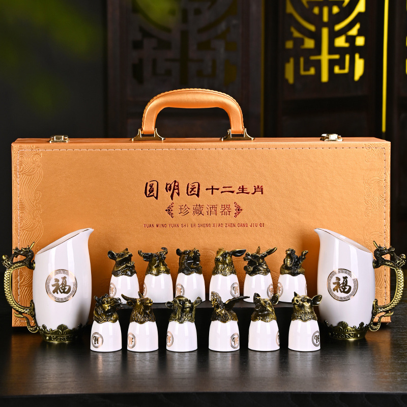 Porcelánból készült, kristályos mázzal bevont tizenkét zodiákus motívumos boros készlet, dupla adagolóval, tizenkét pohárral, fémbázissal és bőr ajándékdobozzal