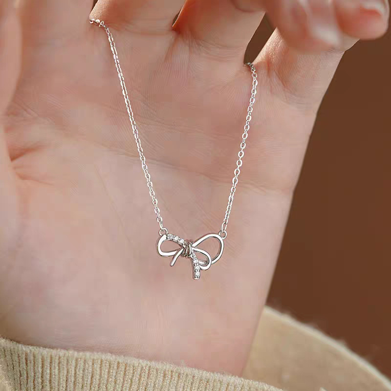 Lančić od srebra 999 sa geometrijskom mašnicom kao privjeskom na križnom lancu