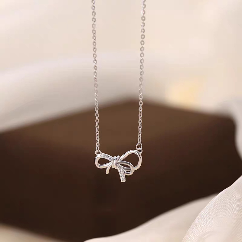 Lančić od srebra 999 sa geometrijskom mašnicom kao privjeskom na križnom lancu