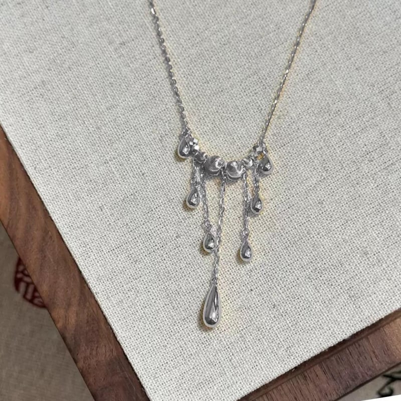 Ogrlica s mačjim okom, resice i kapljica u obliku suze, križni lanac, lagani luksuz
