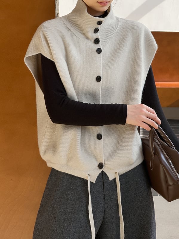 Női ujjatlan kötött mellény álló gallérral, laza szabás, vastagított akril anyagból, egyrészes gombolás