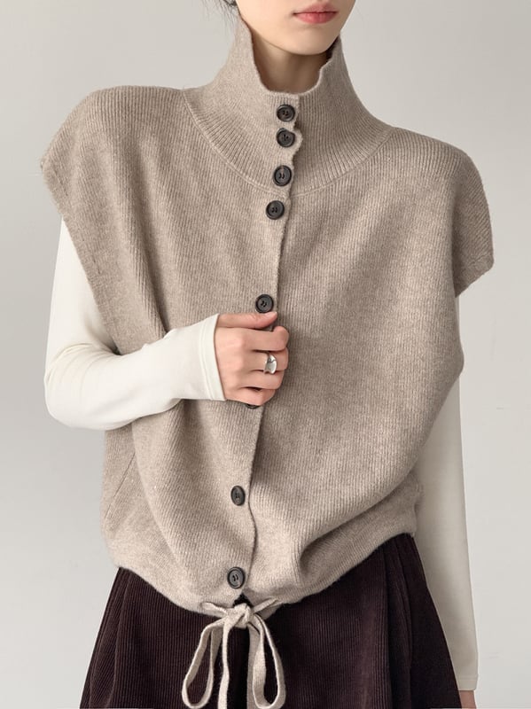 Női ujjatlan kötött mellény álló gallérral, laza szabás, vastagított akril anyagból, egyrészes gombolás