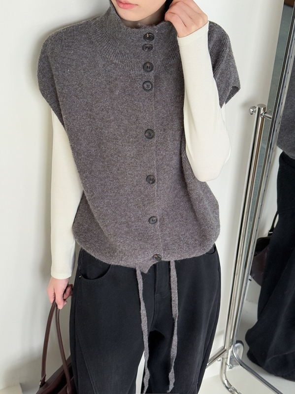 Női ujjatlan kötött mellény álló gallérral, laza szabás, vastagított akril anyagból, egyrészes gombolás