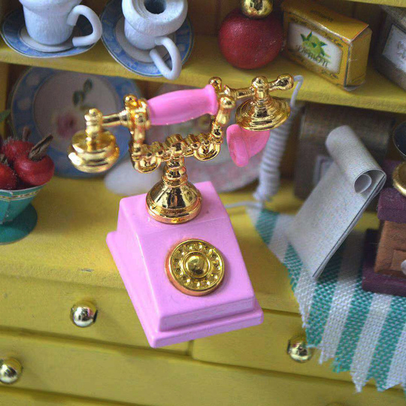 Metalni telefon kao ukras za kućicu za lutke, retro nostalgični dizajn, mini dekorativni model.