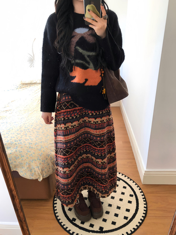 Uska suknja s geometrijskim uzorkom, džepovi i gumbima; srednja duljina; 90–95% poliestera