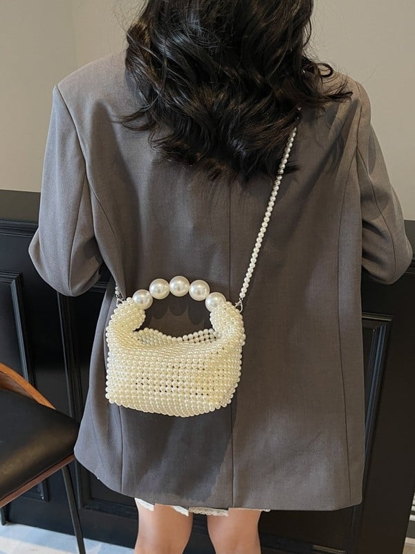 Gyöngyökkel díszített estélyi táska, vertikális négyzetes siluettel, felső nyitás, belső párnázás nélküli, belső telefonzseb zárható.