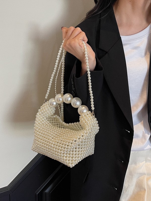 Gyöngyökkel díszített estélyi táska, vertikális négyzetes siluettel, felső nyitás, belső párnázás nélküli, belső telefonzseb zárható.