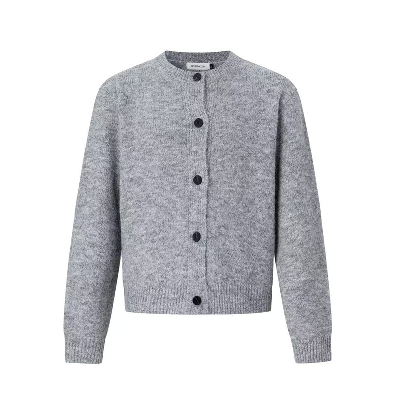 Cardigan tricotat cu nasturi pe față, guler rotund, croială lejeră, mâneci lungi; țesătură din amestec de poliester, 90% poliester.